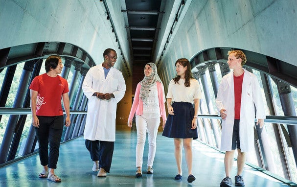 5 people walking in a corridor