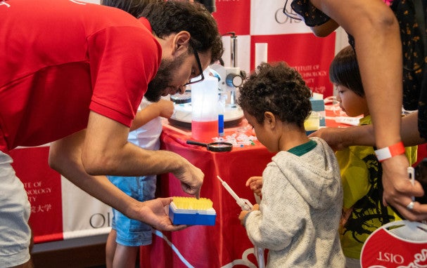 a researcher showing research equipment to children