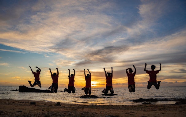 Silhouette of people jumping on the beach