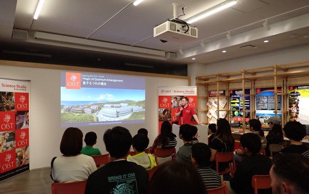 A speaker presenting in front of screen to children