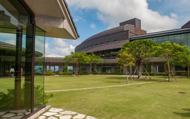 OIST buildings surrounded by a grassy lawn