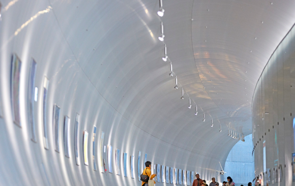 people walking in a white tunnel 