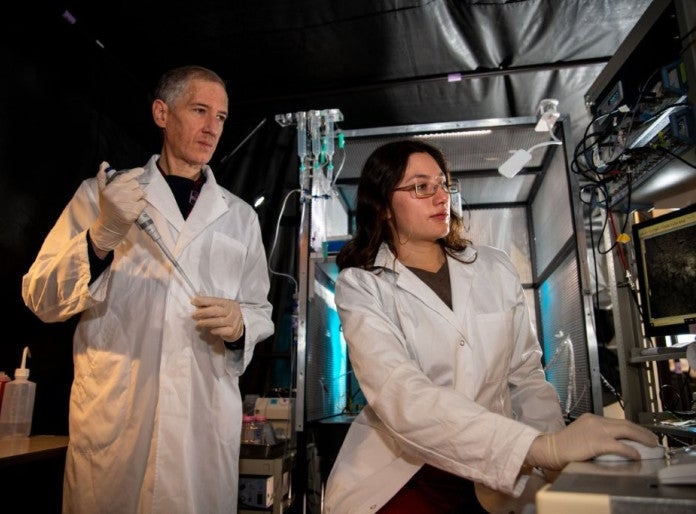 Two researchers in white coat working in a laboratory