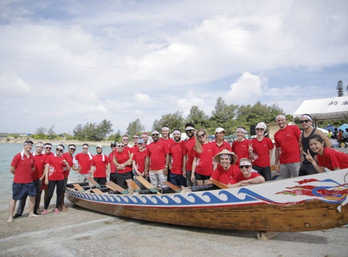 Students wearing red t-sirt around a Harii boat