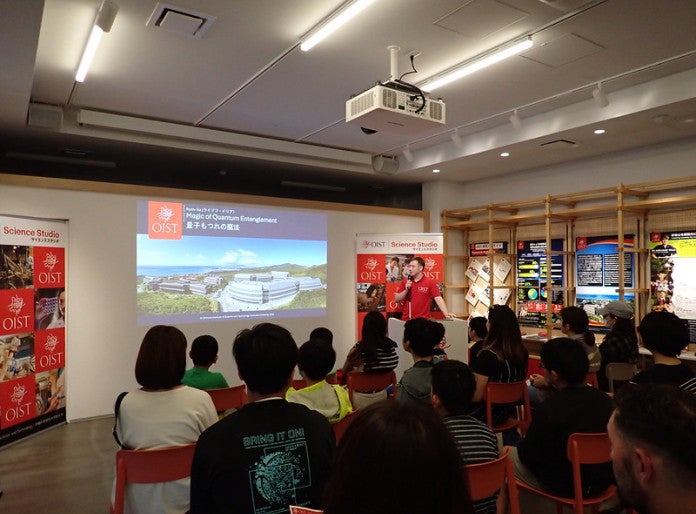 A speaker presenting in front of screen to children