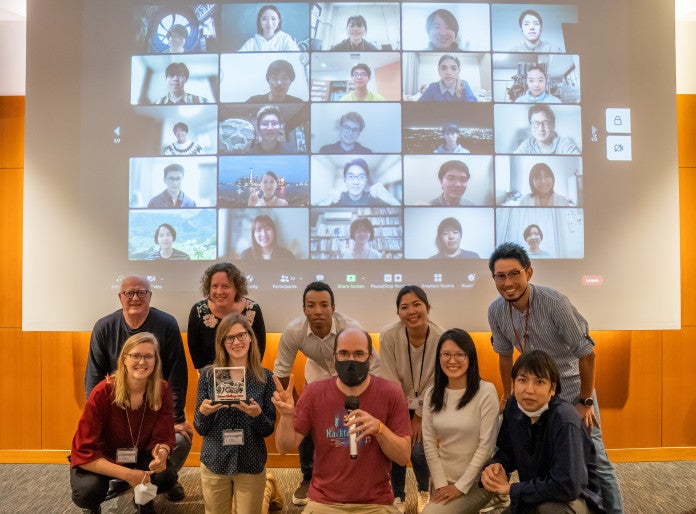 a group of people in front of a screen showing other people's faces