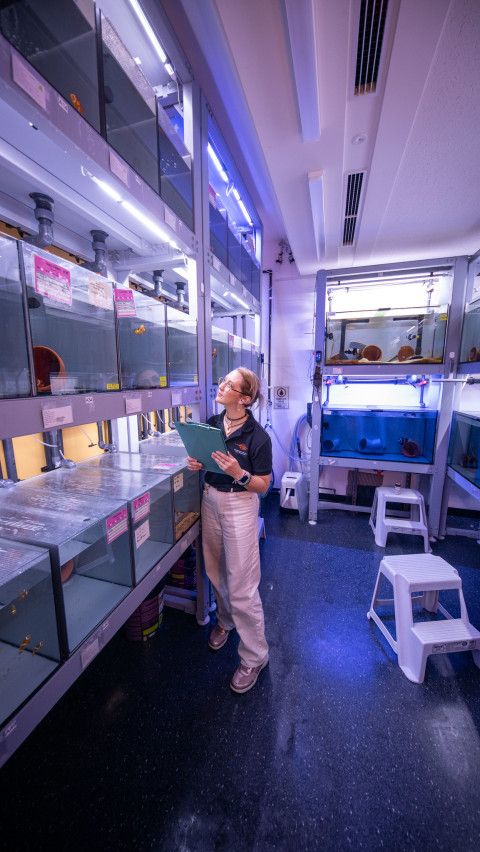 A researcher standing in front of many water tanks