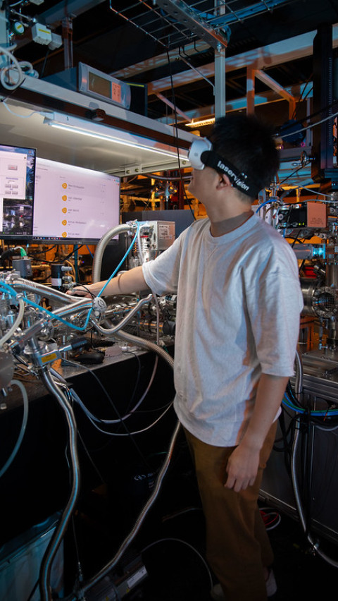 A person wearing a headset in front of machinery and screens